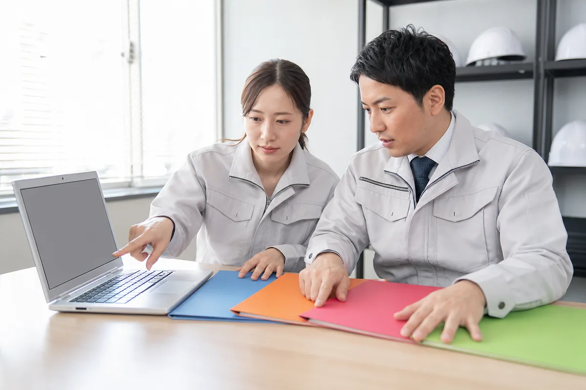 建設業の営業戦略を検討する日本人営業担当者2人の打ち合わせ